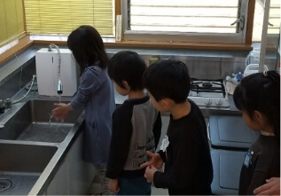 保育園で子どもたちがユニゾーンで作られた水で手を洗っている様子